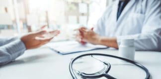 Doctors and patients consulting and diagnostic examining sit and talk. At the table near the window in the hospital medicine concept