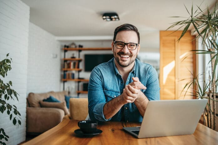 Portrait of a successful entrepreneur at cozy home office, smiling at camera. Portrait of a successful entrepreneur at cozy home office, smiling at camera.