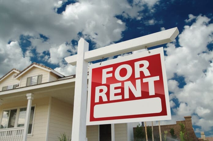 Red and white For Rent sign in front of house
