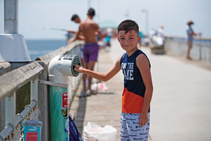 Young angler recylces fishing line in one CBA_s recycling bins located on Okaloosa Island Pier.