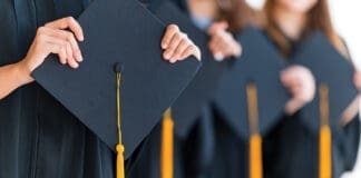 Close up group of graduates holding a hat At the graduation ceremony.