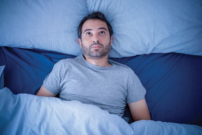 Anxious man trying to sleep but suffering insomnia Anxious man trying to sleep but suffering insomnia