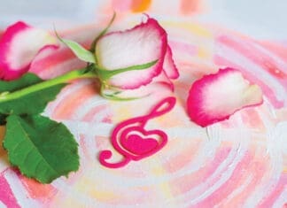Rose with a decorative heart in the shape of a treble clef with pink felt on the background of painting. Valentine's day, mother's day congratulation.
