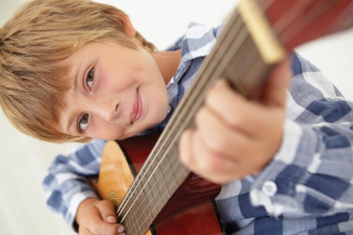 Young boy playing acoustic guitar Young boy playing acoustic guitar