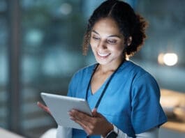 Nurse, medical tablet and black woman in hospital working late on telehealth, research or online consultation. Tech, healthcare or female physician with technology for wellness app in clinic at night