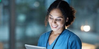 Nurse, medical tablet and black woman in hospital working late on telehealth, research or online consultation. Tech, healthcare or female physician with technology for wellness app in clinic at night