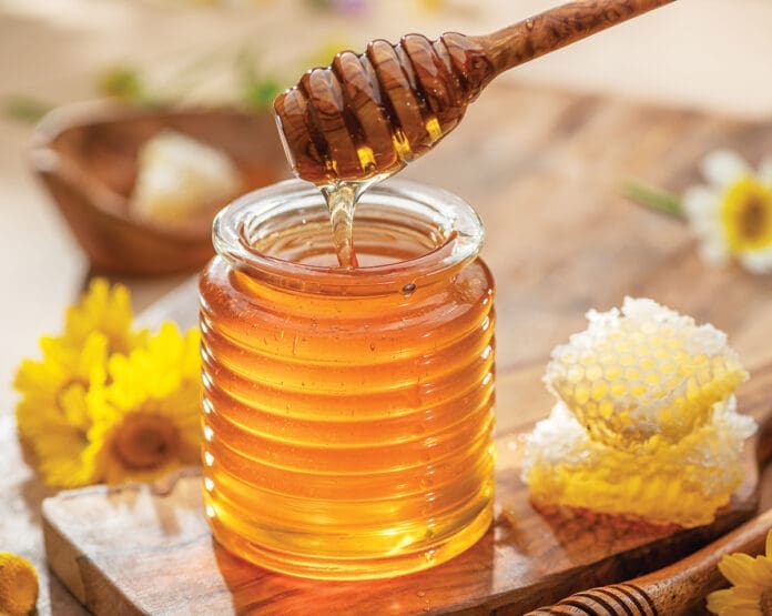 Natural organic honey in glass jar, honey dipper and honeycombs are near. Natural food background. Natural organic honey in glass jar, honey dipper and honeycombs are near. Natural food background.